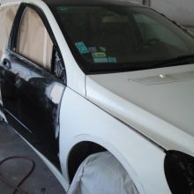 W garażu malowany jest biały samochód.